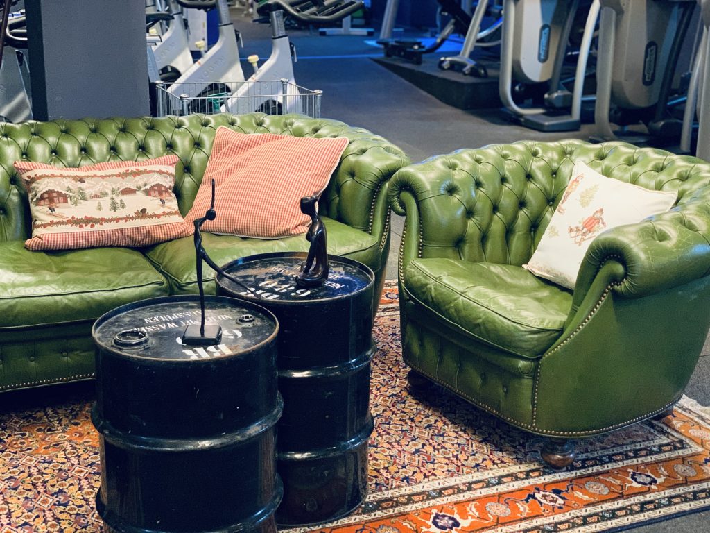 Couch mit 2 alten schwarzen Eisenfässern als Tisch